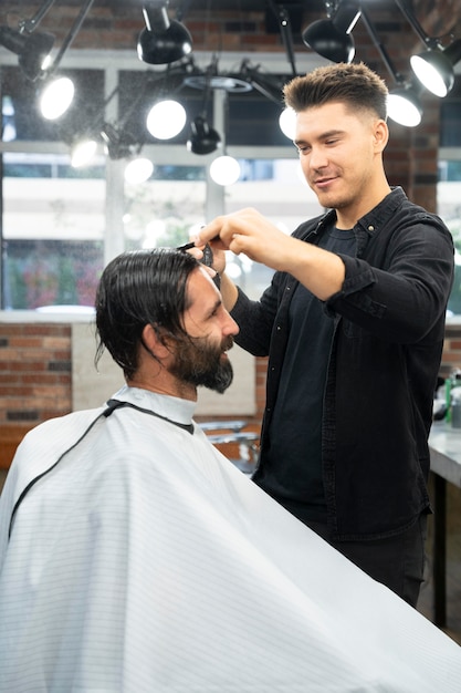 Parrucchiere a colpo medio che pettina i capelli