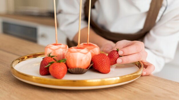 Medium shot hand holding strawberry