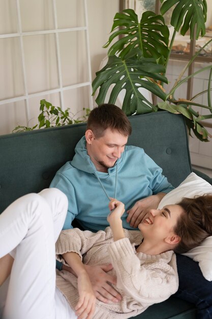 ソファの上でミディアムショットの幸せなカップル