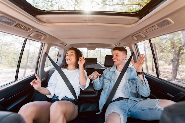 Medium shot happy couple dancing inside car