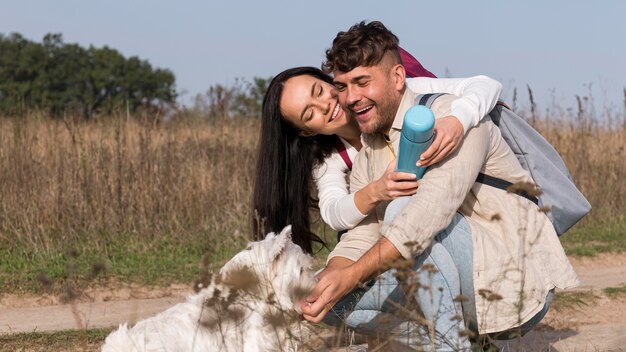 Medium shot happy couple feeding dog