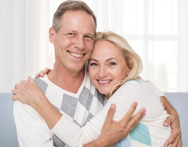 Free photo medium shot happy couple hugging indoors