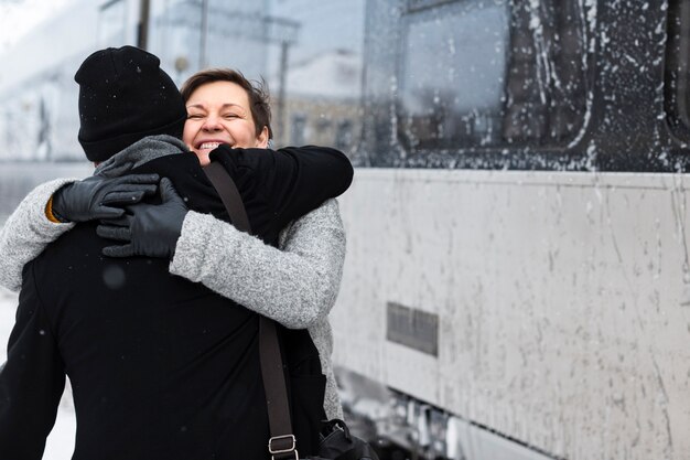 Medium shot happy couple hugging winter season