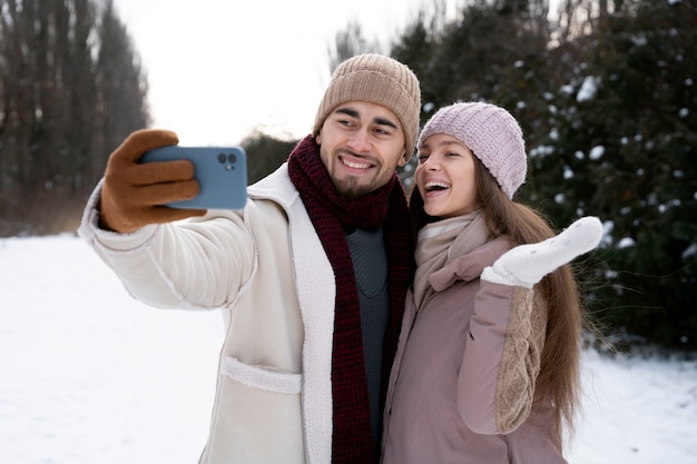 Coppie felici del colpo medio che prendono selfie