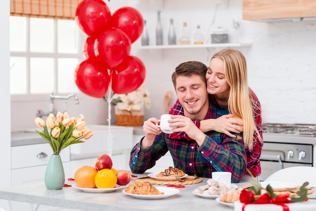Бесплатное фото Средний снимок счастливая пара с завтраком на кухне