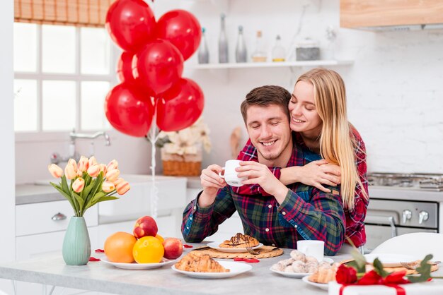 Medium shot happy couple with breakfast in the kitchen