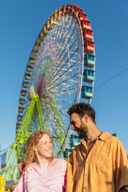 Medium shot happy couple with carnival wheel