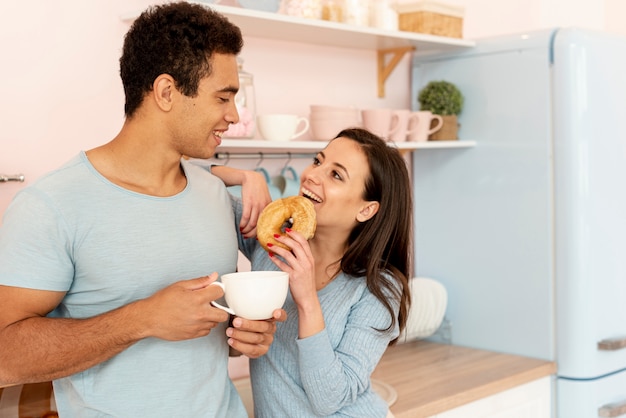 도넛과 컵 중간 샷 행복 한 커플