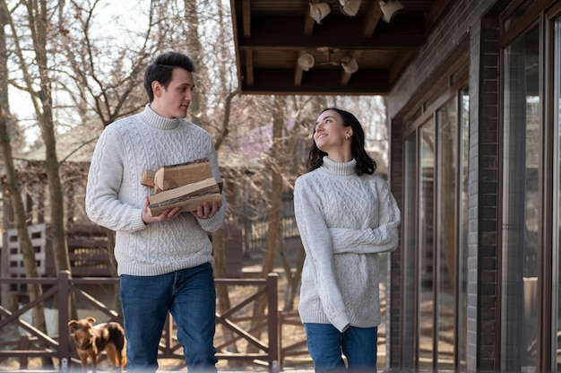 Free photo medium shot happy couple with firewood