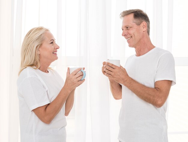 Medium shot happy couple with mugs