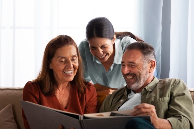 Medium shot happy family looking at picture album