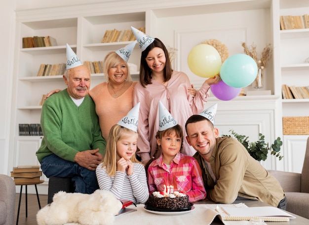 Medium shot happy family posing with cake
