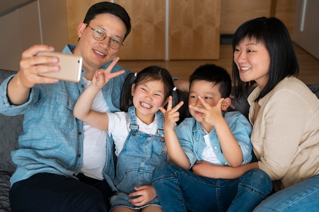 Medium shot happy family taking selfie