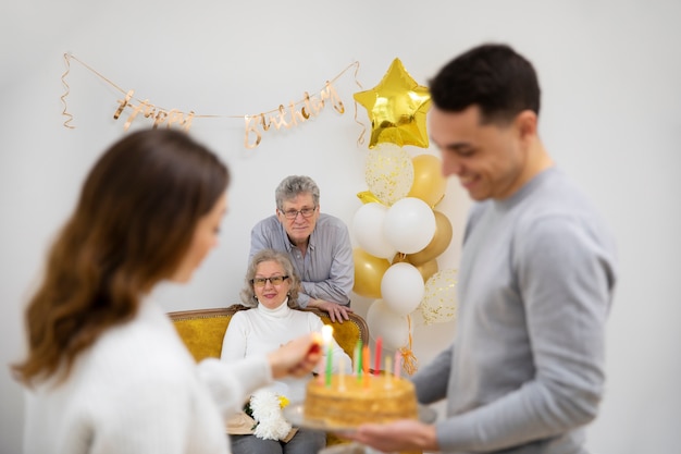 Средний снимок счастливая семья с тортом