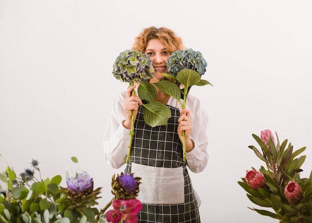 Medium shot happy florist holding up two bouquets