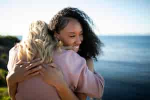 Free photo medium shot happy friends hugging outdoors