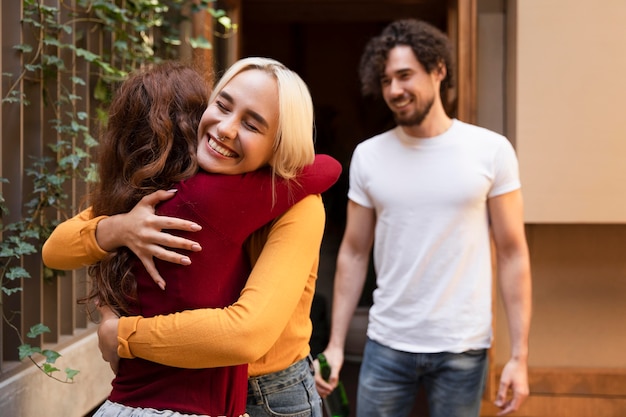 Medium shot happy friends hugging