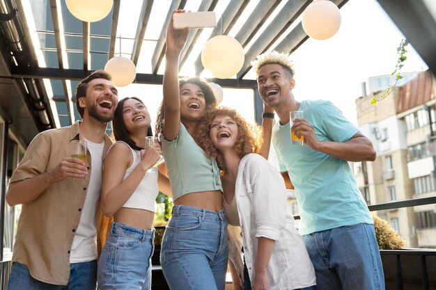 Amici felici del tiro medio che prendono selfie