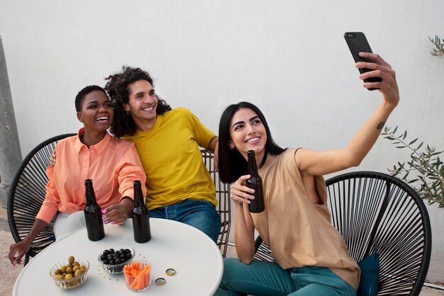 medium shot happy friends taking selfie