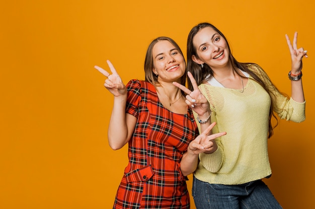 Ragazze felici del colpo medio che fanno il segno di pace