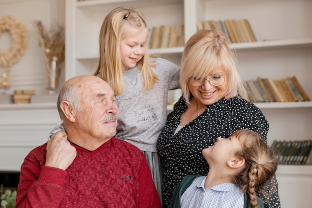Средний снимок счастливых девочек, бабушек и дедушек