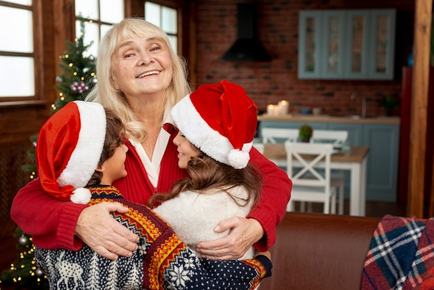 Medium shot happy grandmother hugging grandchildren