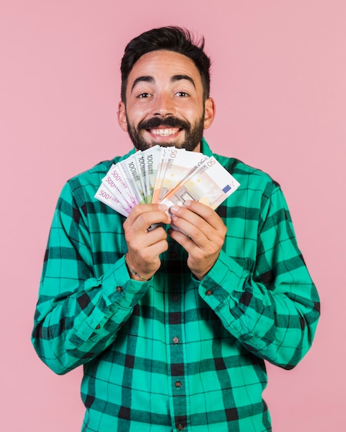 Medium shot happy guy holding money 