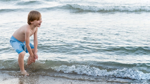 Средний снимок счастливый ребенок на берегу моря