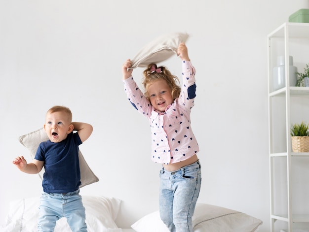 Medium shot happy kids playing in the bedroom