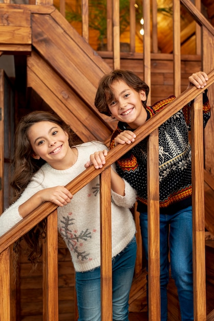 Medium shot happy kids standing on the stairs