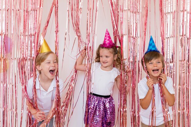 Medium shot happy kids wearing party hats