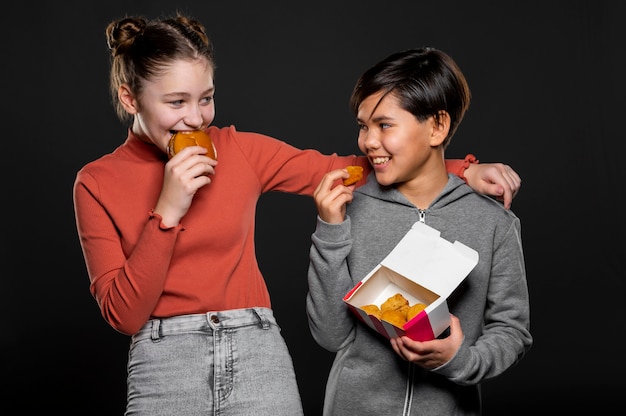 Medium shot happy kids with fast food