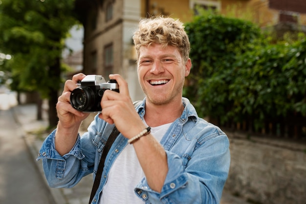 Средний снимок счастливый человек, держащий камеру