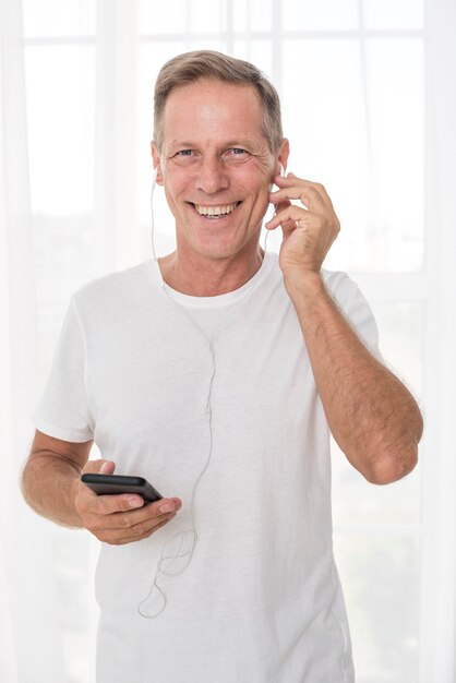 Medium shot happy man with smartphone and headphones