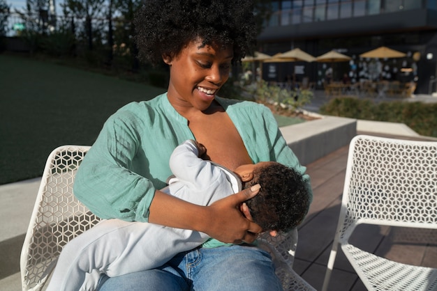 Bambino che allatta al seno la madre felice del colpo medio