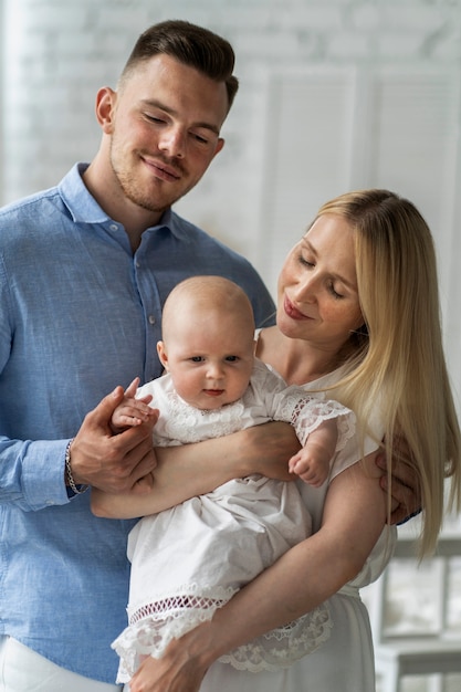 아기를 안고 중간 샷 행복한 부모