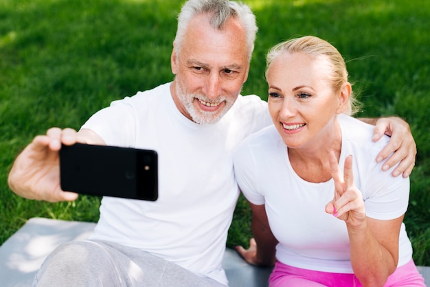 Medium shot happy people taking selfies outdoors