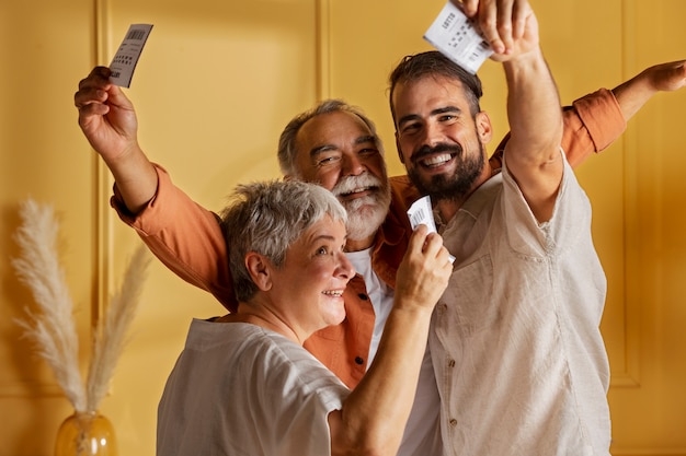 Medium shot happy people with lottery tickets