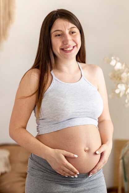 Medium shot happy pregnant female indoors