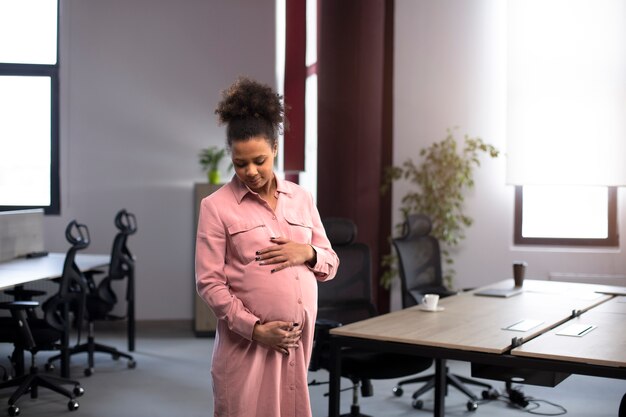 Medium shot happy pregnant woman at work