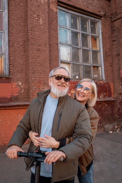 Medium shot happy senior couple on electric scooter