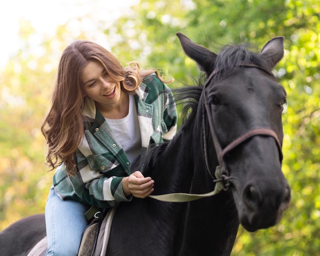 Medium shot happy woman riding horse