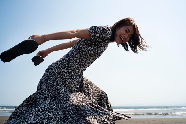 Medium shot happy woman running on beach