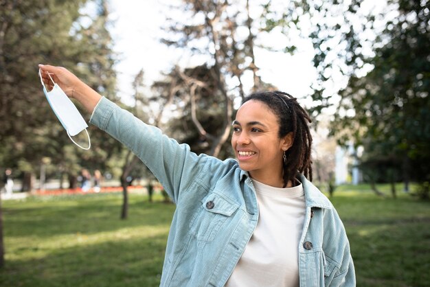 Medium shot happy woman taking mask off