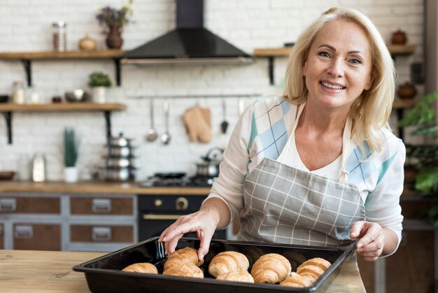 Medium shot happy woman with croissants