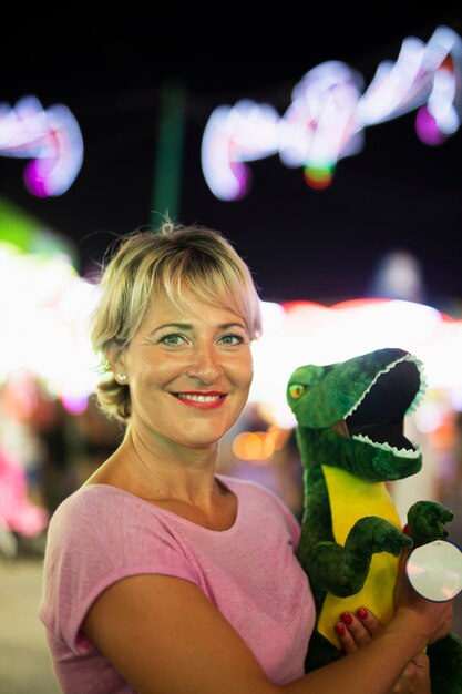 Medium shot happy woman with dinosaur toy