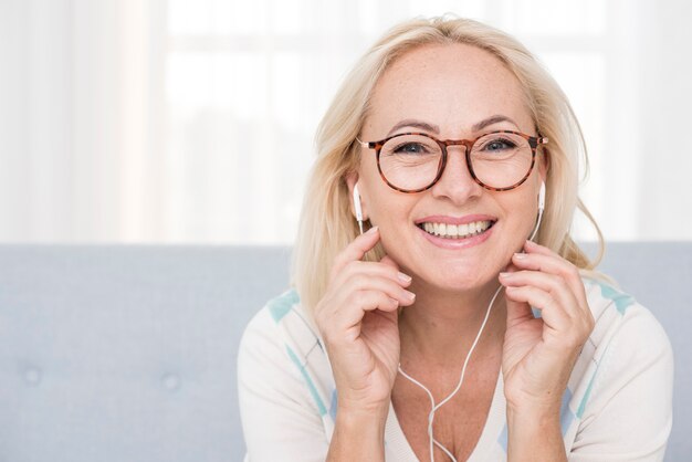 Medium shot happy woman with glasses and headphones