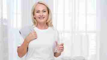 Free photo medium shot happy woman with towel and water bottle