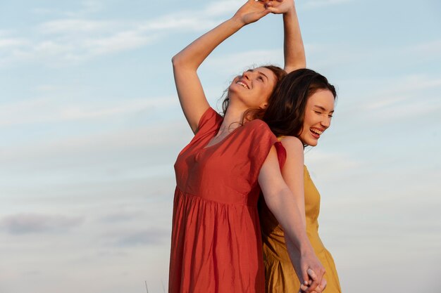 Medium shot happy women dancing outdoors