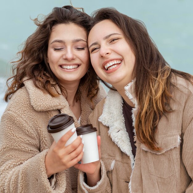 コーヒーカップとミディアムショットの幸せな女性